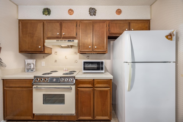 kitchen featuring backsplash and white appliances