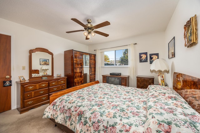 carpeted bedroom with a textured ceiling and ceiling fan