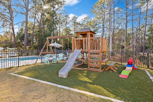 view of play area featuring a fenced in pool and a lawn