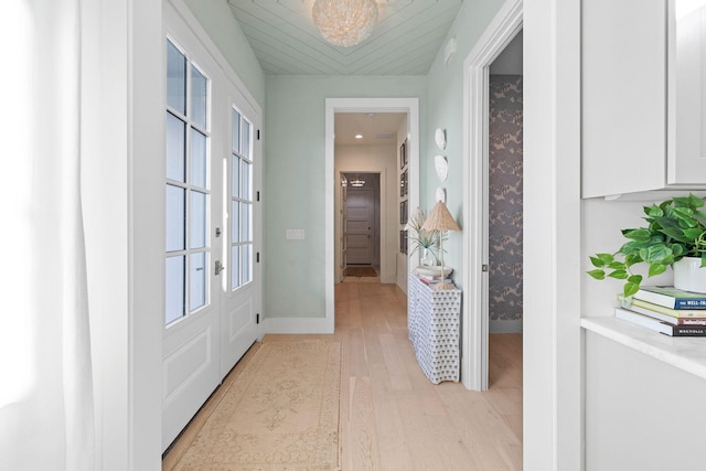 hallway with french doors and light hardwood / wood-style flooring