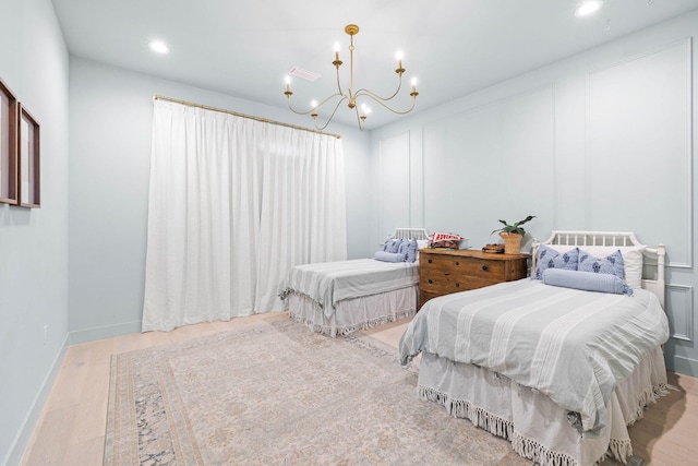 bedroom featuring light hardwood / wood-style floors and a notable chandelier