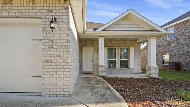 view of exterior entry featuring covered porch and central AC unit