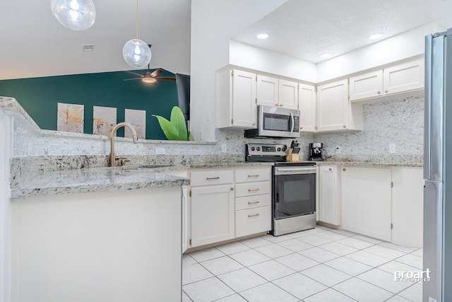 kitchen with decorative light fixtures, sink, tasteful backsplash, appliances with stainless steel finishes, and white cabinets