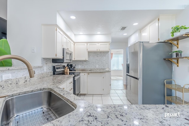 kitchen with white cabinetry, backsplash, appliances with stainless steel finishes, and sink