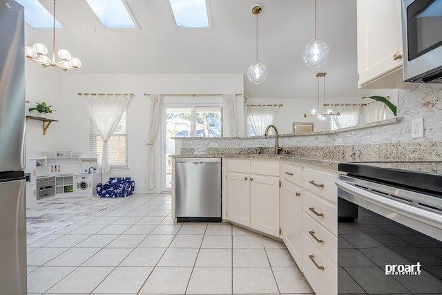 kitchen featuring white cabinetry, hanging light fixtures, sink, backsplash, and appliances with stainless steel finishes