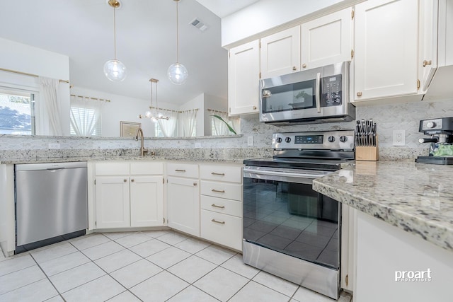 kitchen featuring white cabinetry, appliances with stainless steel finishes, tasteful backsplash, and hanging light fixtures