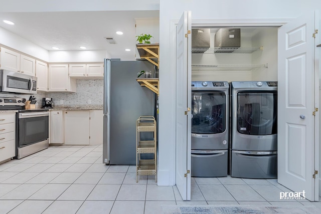 laundry area featuring light tile patterned floors and independent washer and dryer