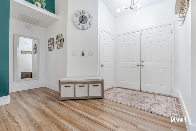 foyer with light hardwood / wood-style floors and a notable chandelier