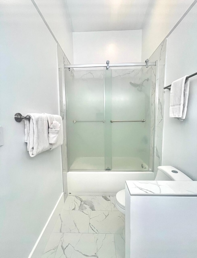 bathroom featuring enclosed tub / shower combo and toilet