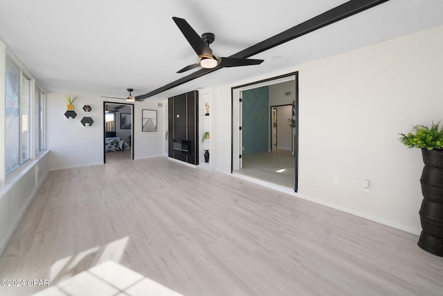 unfurnished living room with light wood-type flooring and ceiling fan