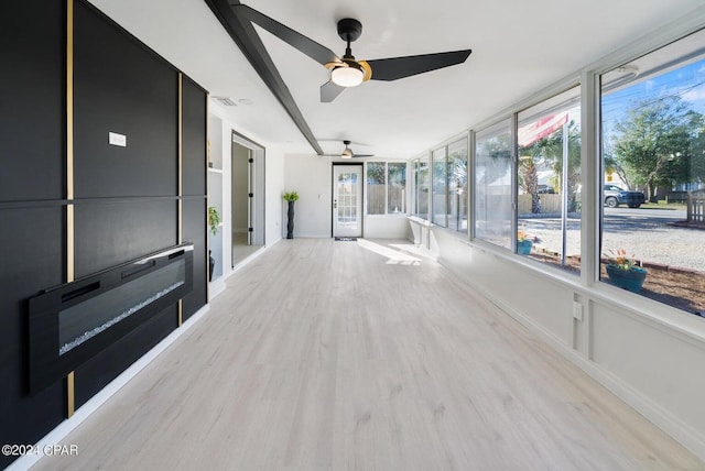 unfurnished sunroom with ceiling fan