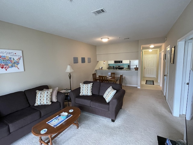 carpeted living room featuring a textured ceiling