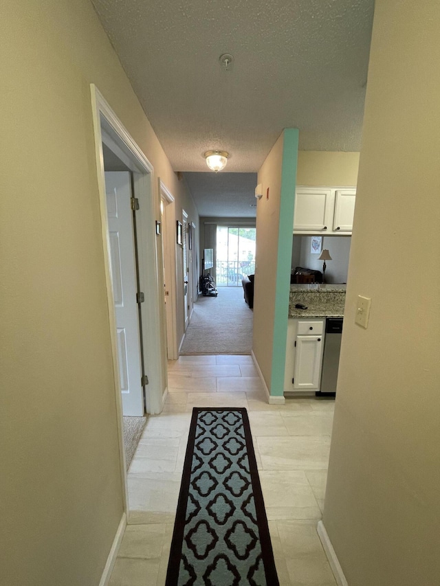 hall featuring a textured ceiling