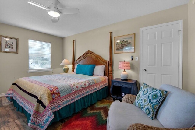 bedroom with dark hardwood / wood-style flooring and ceiling fan