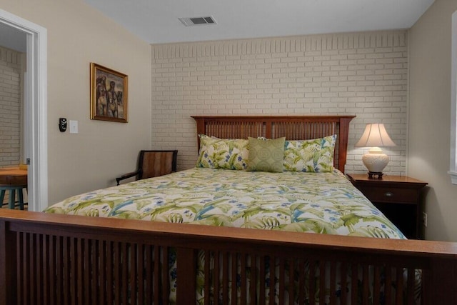 bedroom featuring brick wall