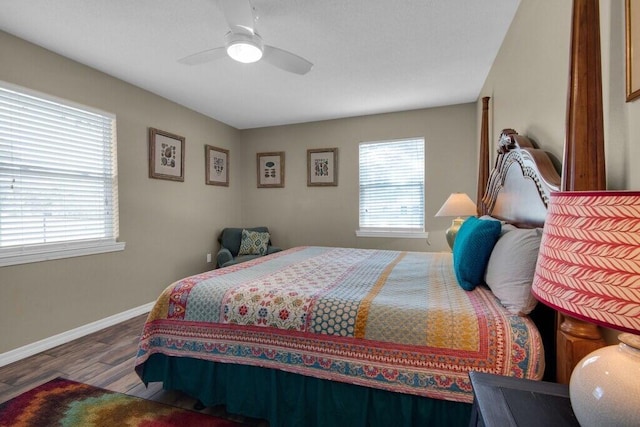 bedroom with ceiling fan, wood-type flooring, and multiple windows