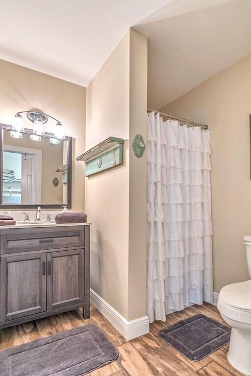 bathroom with vanity, toilet, and wood-type flooring