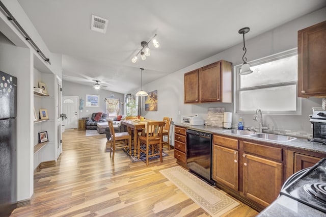 kitchen with ceiling fan, dishwasher, sink, a barn door, and decorative light fixtures