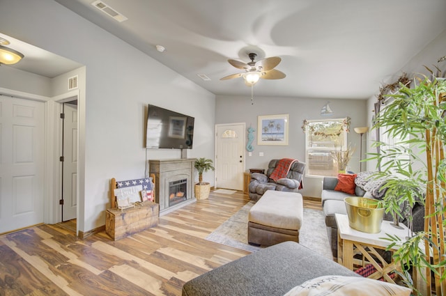 living room with hardwood / wood-style floors, ceiling fan, and lofted ceiling