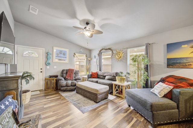 living room featuring ceiling fan, wood-type flooring, and vaulted ceiling