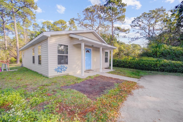 view of front of home with a porch and a front yard