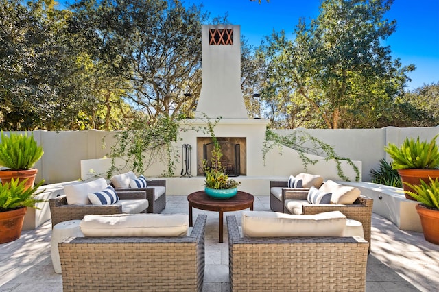 view of patio / terrace featuring an outdoor living space with a fireplace and a fenced backyard