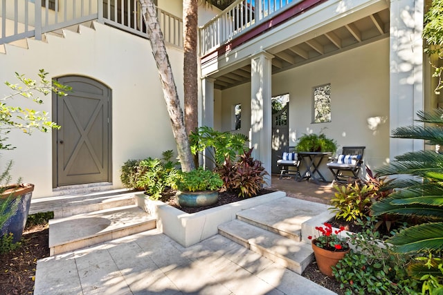 doorway to property featuring a balcony and stucco siding