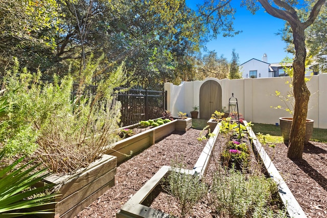 view of yard featuring fence and a vegetable garden