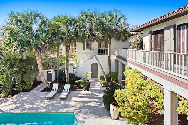 exterior space featuring a patio area, a swimming pool, and stairs