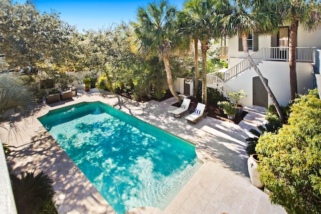 pool featuring a patio and stairs