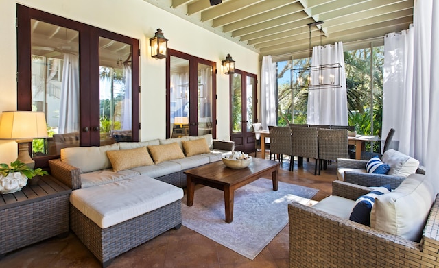 sunroom featuring french doors and a notable chandelier