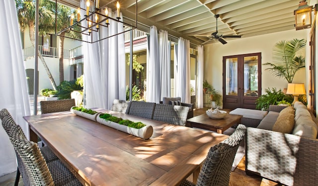 sunroom with french doors and ceiling fan with notable chandelier