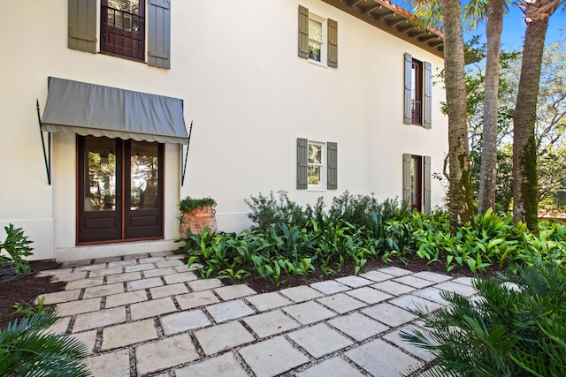 entrance to property featuring french doors and stucco siding