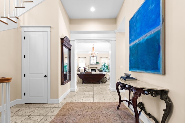 entrance foyer with a chandelier, baseboards, and light tile patterned floors