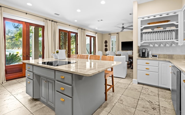 kitchen with a center island, french doors, gray cabinetry, a kitchen breakfast bar, and black electric cooktop