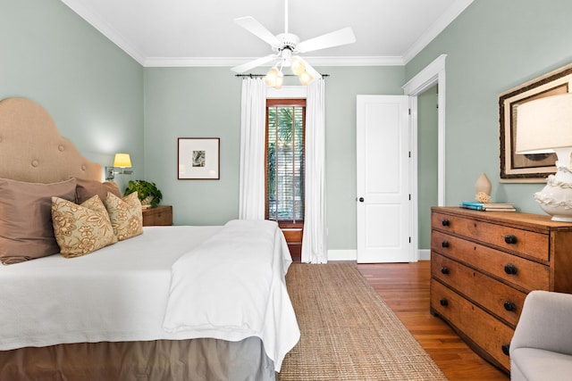 bedroom with baseboards, wood finished floors, and crown molding