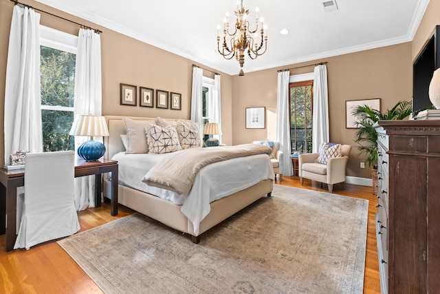 bedroom featuring a chandelier, light wood-style flooring, visible vents, baseboards, and ornamental molding