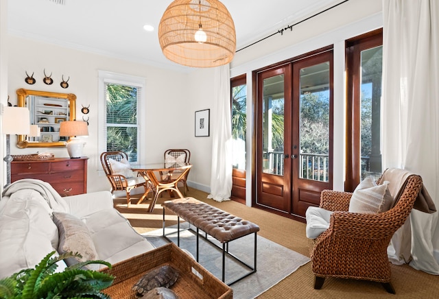 living area with plenty of natural light, french doors, carpet flooring, and crown molding