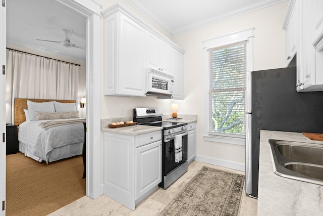 kitchen with white cabinets, light countertops, ornamental molding, appliances with stainless steel finishes, and plenty of natural light