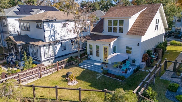 back of house with a lawn and a deck