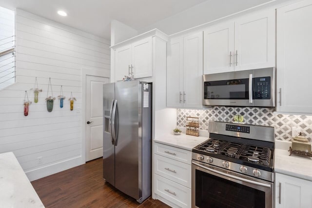 kitchen featuring stainless steel appliances, dark hardwood / wood-style flooring, white cabinets, and tasteful backsplash