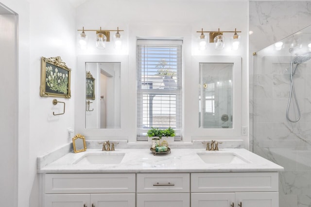 bathroom with a tile shower and vanity