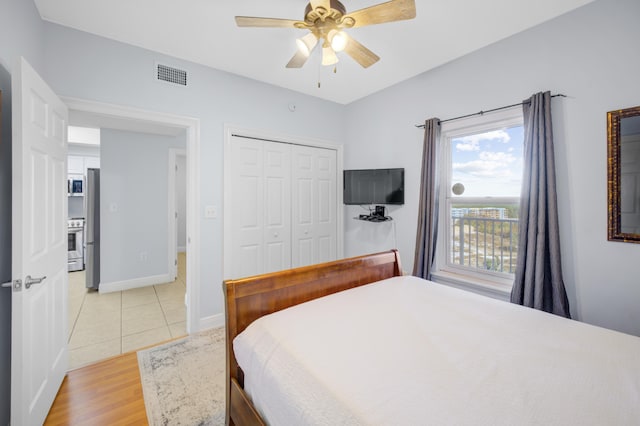 bedroom featuring ceiling fan, a closet, and light wood-type flooring