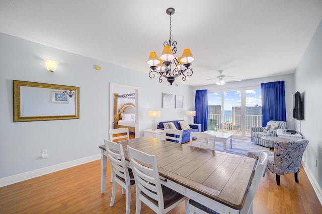 dining area with light hardwood / wood-style flooring and ceiling fan with notable chandelier