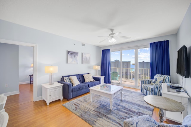 living room with light hardwood / wood-style floors and ceiling fan