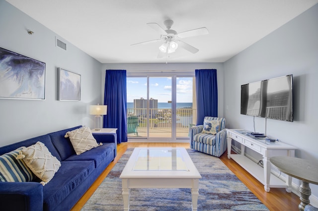 living room featuring hardwood / wood-style floors and ceiling fan