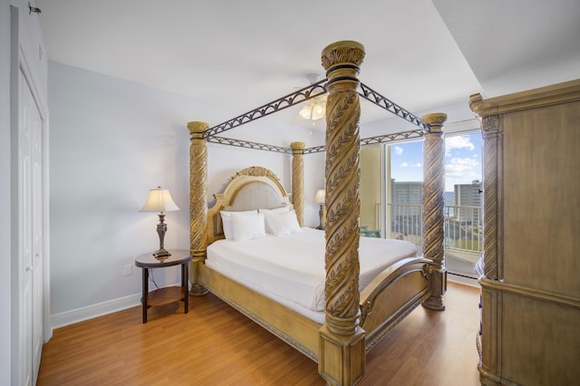 bedroom with hardwood / wood-style flooring, baseboard heating, and ceiling fan