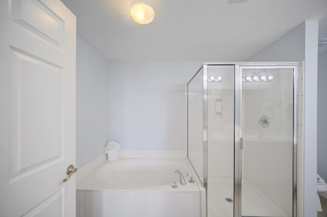 bathroom featuring separate shower and tub, a textured ceiling, and toilet