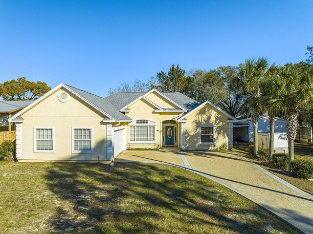 ranch-style house featuring a front yard and a garage