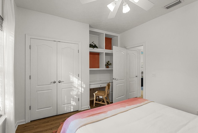 bedroom with dark hardwood / wood-style flooring, ceiling fan, and a closet